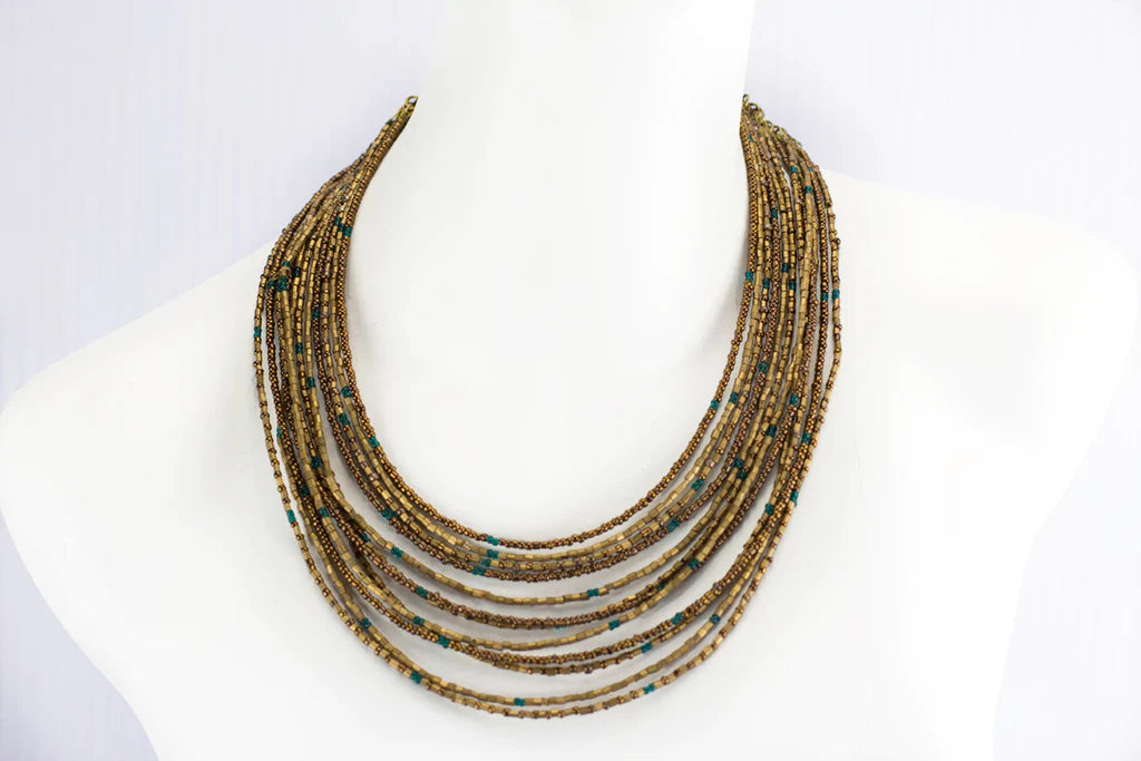 Photo of Handmade Stacked Grecian Goddess Necklaces from India. Each necklace has 12 strands of bronze, chocolate, and teal beads, adding texture and depth to any outfit. The necklaces are 14" long with a 4" extension chain, and can be worn together or separately for a chic and versatile look.