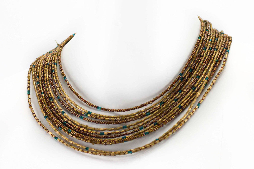 Photo of Handmade Stacked Grecian Goddess Necklaces from India. Each necklace has 12 strands of bronze, chocolate, and teal beads, adding texture and depth to any outfit. The necklaces are 14" long with a 4" extension chain, and can be worn together or separately for a chic and versatile look.