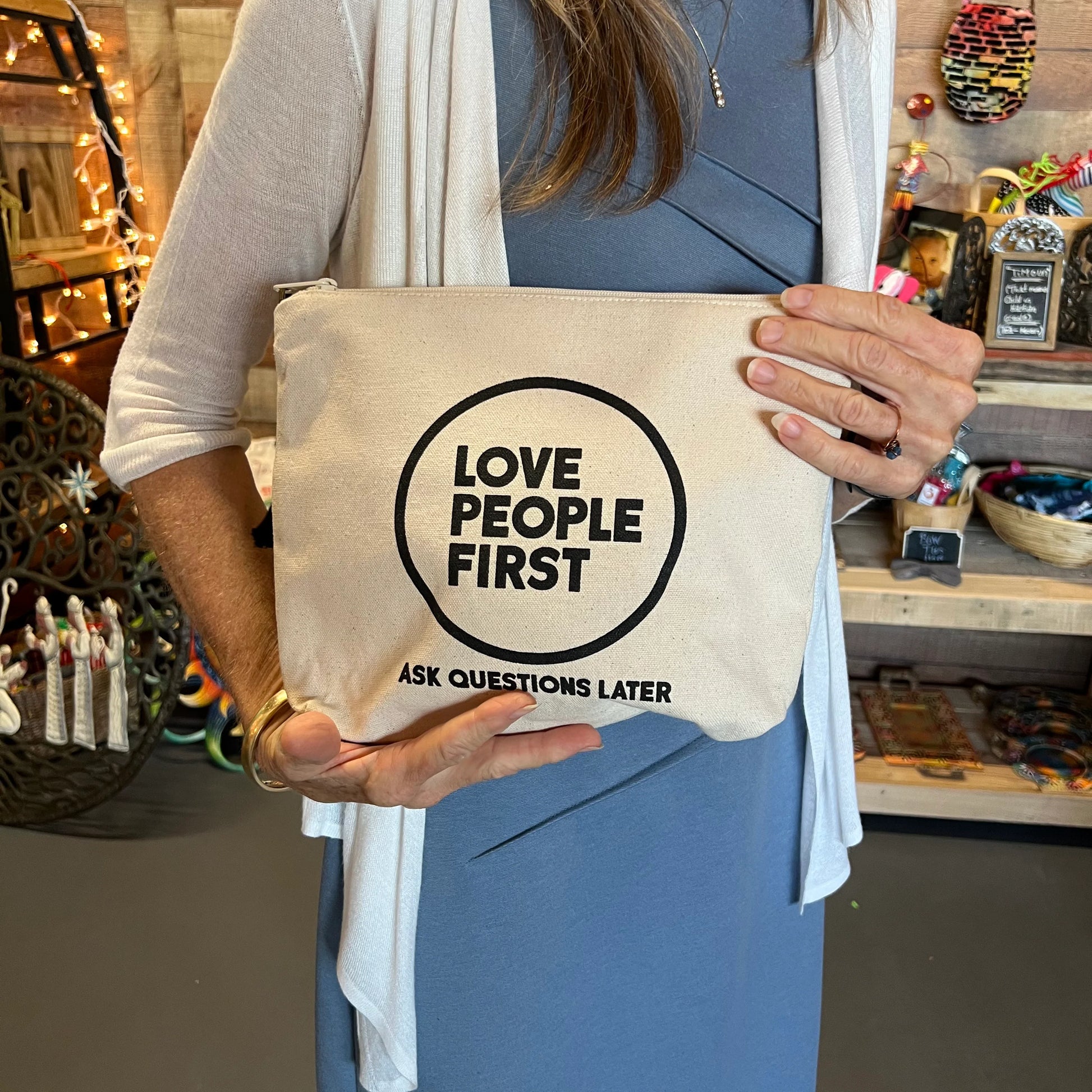 The "Love People First" Canvas Zipper Bag, a versatile and meaningful accessory that serves as a powerful reminder to prioritize compassion and understanding in our daily interactions. With the bold statement "Love People First - Ask Questions Later" printed on the front, this bag encourages us to embrace empathy and connection with others.
