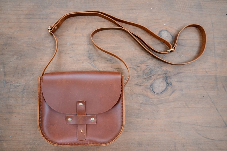 Photo of the Leather Crossbody Purse, showcasing the premium quality leather and artisanal detailing handcrafted by skilled artisans in India. The classic crossbody design ensures comfortable wear. The photo shows the purse with a focus on the unique detailing and the versatile design that makes it perfect for any occasion.